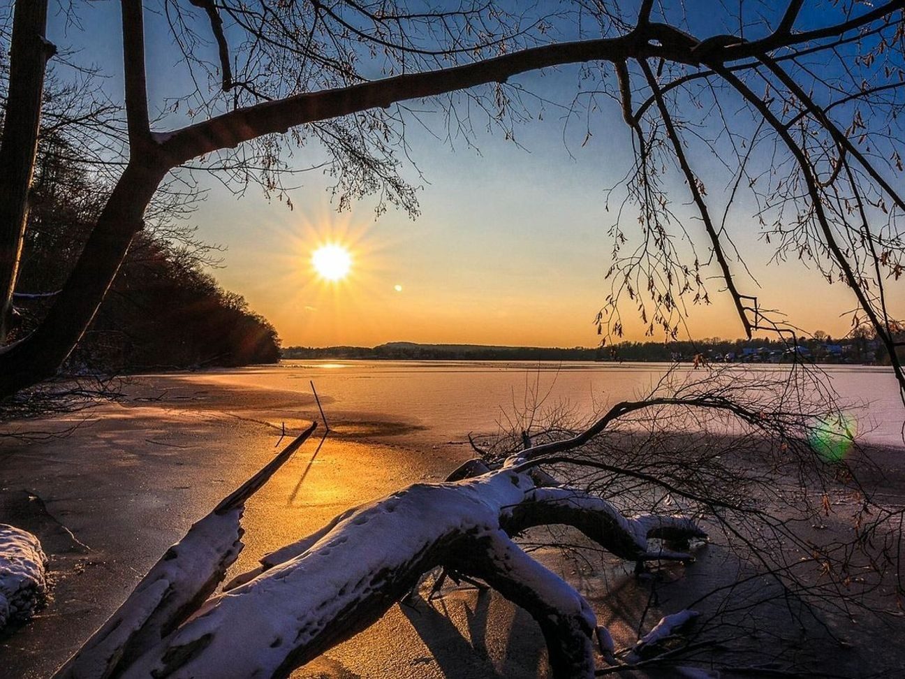 Superficie tranquila del lago bajo el hielo rodeado de cerros bajos